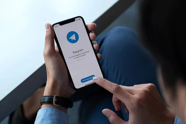 ЧЬЯН-ИЙ, ТАИЛАНД, 17 января 2021 года: Мужчина держит в руках iPhone X с сервисом социальной сети Telegram на экране. iPhone 10 был создан и разработан Apple inc. — стоковое фото