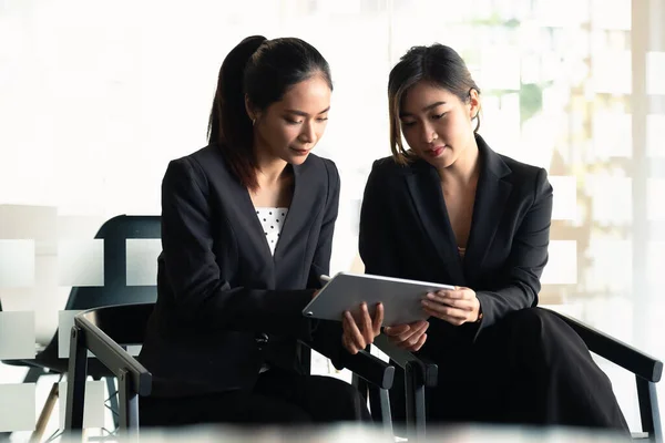 Due Businesswoman discutere di lavorare con l'utilizzo di tablet e per la ricerca di informazioni grafico del mercato azionario per il trading per realizzare un profitto. Concetto di pianificazione e investimento — Foto Stock