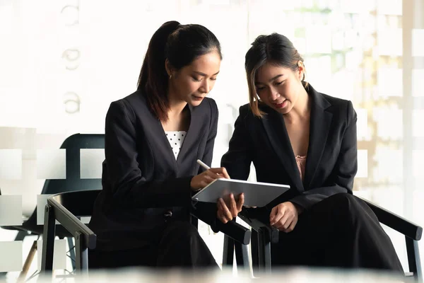 Due Businesswoman discutere di lavorare con l'utilizzo di tablet e per la ricerca di informazioni grafico del mercato azionario per il trading per realizzare un profitto. Concetto di pianificazione e investimento — Foto Stock