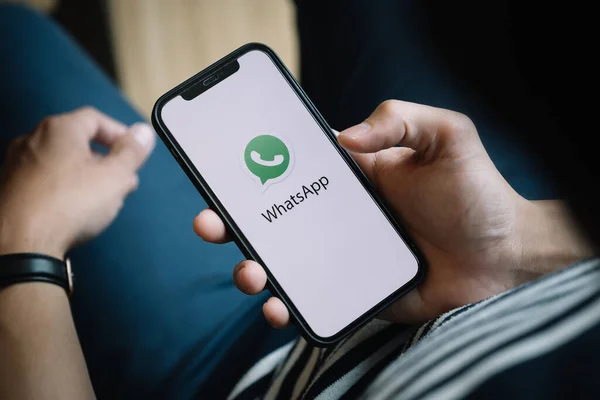 CHIANGMAI, THAILAND - JAN 23, 2021: Manliga handen håller WhatsApp mobil applikation på Apple iPhone 12 skärmdump. — Stockfoto