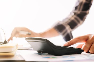 Ofisteki mali hesapları hesaplamak için dizüstü bilgisayarla çalışan iş adamı veya muhasebeci