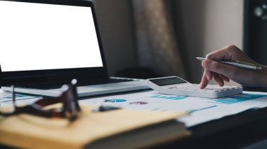 Finans işlerini yapan adamı kapat ve masasında hesap makinesiyle ev konseptinin maliyetini hesapla.