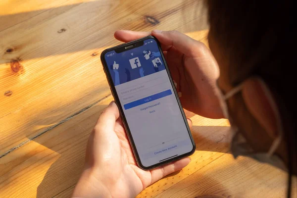 CHIANG MAI, THAILAND MAR 7, 2021: Logo aplikasi media sosial Facebook pada log-in, sign-up registrasi halaman pada layar aplikasi mobile pada iPhone X orang tangan bekerja pada bisnis belanja e-commerce — Stok Foto