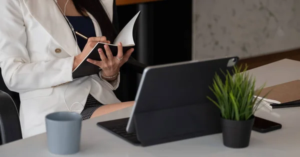 Woman with video conference note some data on notepad for protection covid-19.woman using tablet webinar video course at home office.- education or business online concept