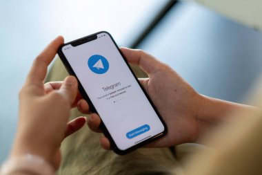 CHIANG MAI, THAILAND - 11 Nisan 2021: Ekranda sosyal ağ hizmetleri telgrafı ile iPhone X 'i tutan kadın. iPhone 10 Apple Inc. tarafından oluşturuldu ve geliştirildi