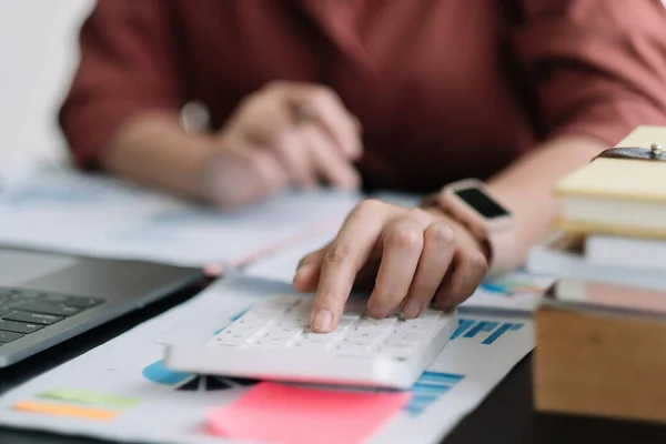 Affärskvinna med hjälp av miniräknare för att göra matematik finans på trä skrivbord i kontor, skatt, redovisning, statistik hem bokföring koncept. — Stockfoto