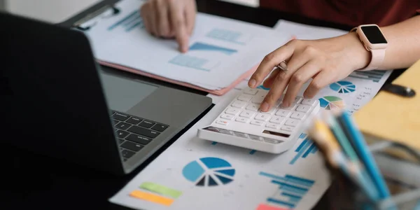 Revisor arbetar på skrivbord med hjälp av räknare för beräkning av finansrapport i ämbetet — Stockfoto