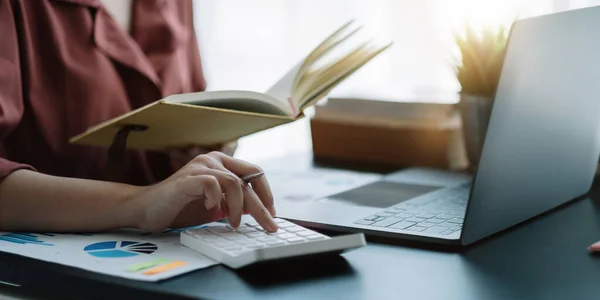 Affärskvinna med hjälp av miniräknare för att göra matematik finans på trä skrivbord i kontor, skatt, redovisning, statistik hem bokföring koncept. — Stockfoto