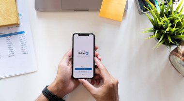 CHIANG MAI, THAILAND, APR 15, 2021: Bir adam ekranda LinkedIn uygulamalı Apple iPhone X 'leri tutuyor. LinkedIn akıllı telefonlar için fotoğraf paylaşım uygulaması