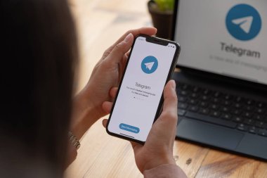 CHIANG MAI, THAILAND, MAR 21, 2021: Ekranda sosyal ağ hizmetleri telgrafıyla iPhone X 'i tutan kadın. iPhone 10 Apple Inc. tarafından oluşturuldu ve geliştirildi