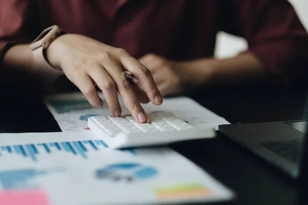 Närbild en kvinna som arbetar med ekonomi med miniräknare i sitt hem för att beräkna kostnader, Redovisning koncept. — Stockfoto