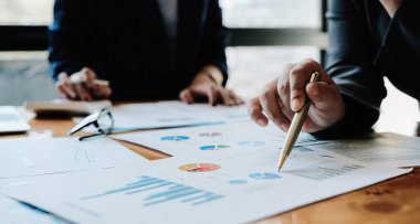 İş Adamları Tasarım Fikirleri Buluşması. Yatırımcıların çeşitli beyin fırtınaları ve ahşap masadaki dizüstü bilgisayarları gösteriyor.