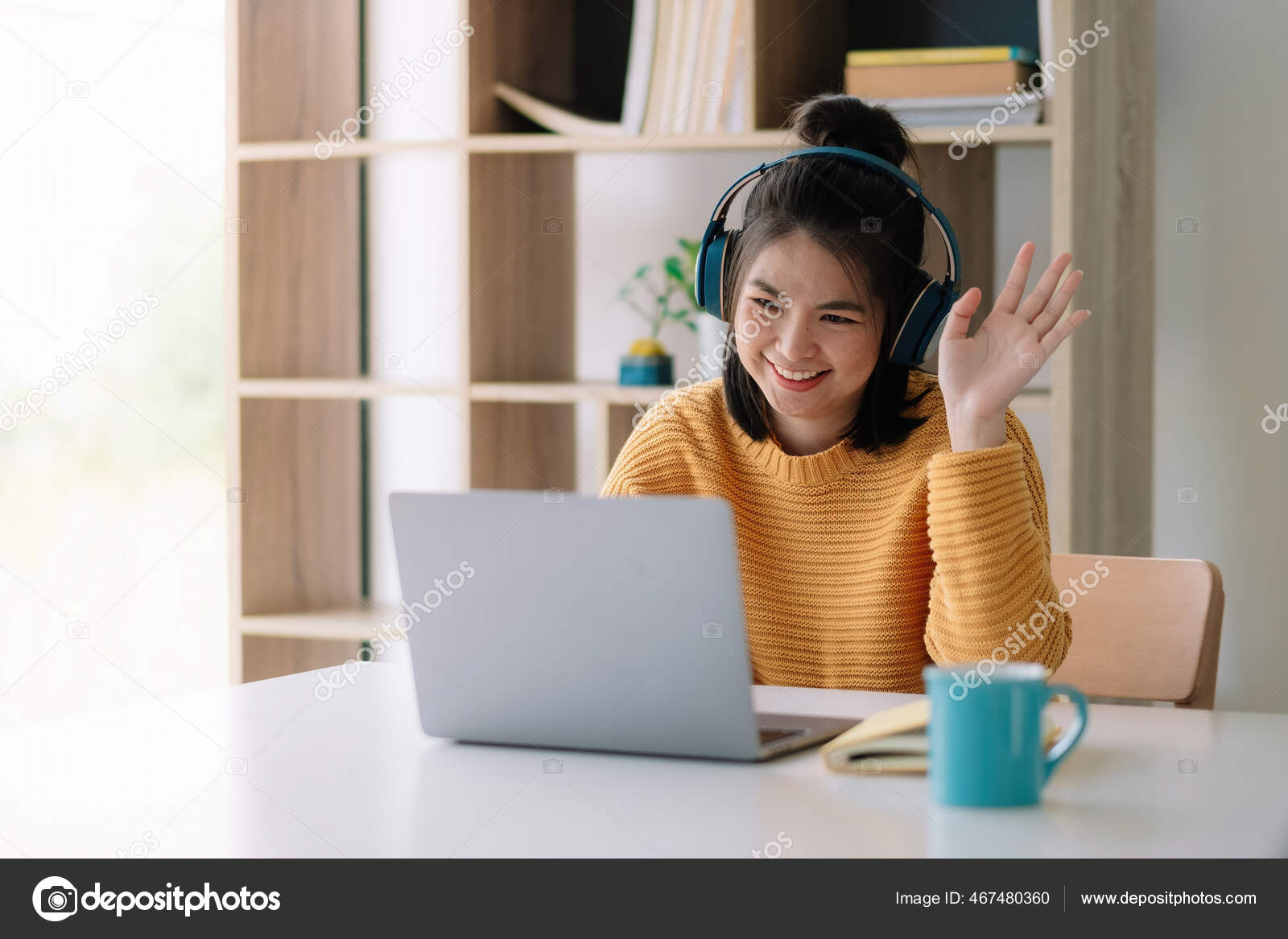 Happy young asian ethnicity female manager wearing wireless headphones