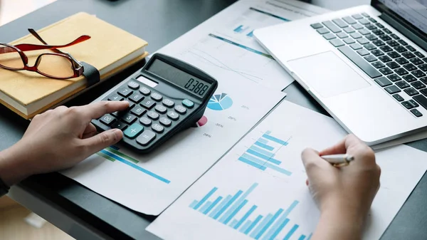 Калькулятор и ноутбук бизнес-женщины для расчета финансов, налогов, бухгалтерского учета, статистики и аналитических исследований — стоковое фото