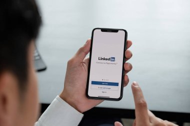 CHIANG MAI, THAILAND, APR 06, 2019: Bir adam ekranda linkedIn uygulamalı Apple iPhone X 'leri tutuyor. LinkedIn akıllı telefonlar için fotoğraf paylaşım uygulaması