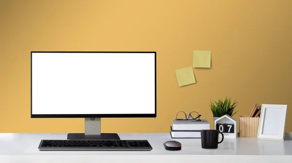 Vyhonit počítač s prázdnou bílou obrazovkou a Office Supply položky na Word Desk domácí dekor s obrázkovým rámečkem pracovní prostor s kopírovacím prostorem pro produkty zobrazení montáže. — Stock fotografie