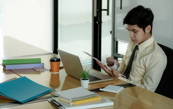 Hombre de negocios asiático trabajando en documentos que buscan concentrado con maletín sobre la mesa. —  Fotos de Stock