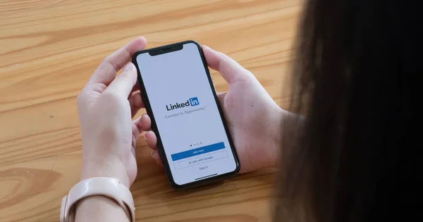 CHIANG MAI, THAILAND, JUN 6, 2021: A women holds Apple iPhone Xs with LinkedIn application on the screen.LinkedIn é um aplicativo de compartilhamento de fotos para smartphones — Fotografia de Stock