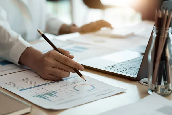 Primer plano de la mujer de negocios o contador de mano pluma que sostiene trabajando en la calculadora para calcular los datos comerciales, documento de contabilidad y computadora portátil en la oficina, concepto de negocio — Foto de Stock