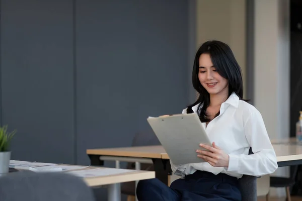 Retrato de sucesso jovem empresária asiática trabalhando com relatório financeiro em seu escritório — Fotografia de Stock