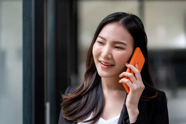 Close up asiático mulher de negócios fazendo um telefonema e sorrindo no escritório — Fotografia de Stock