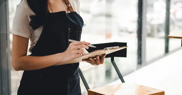 Close up weibliche Kellnerin bestellen Café Restaurant Besucher paar, freundliche professionelle Frau Server tragen Schürze schreiben Abendessen Menüwahl, serviert Personal guten Kundenservice. — Stockfoto