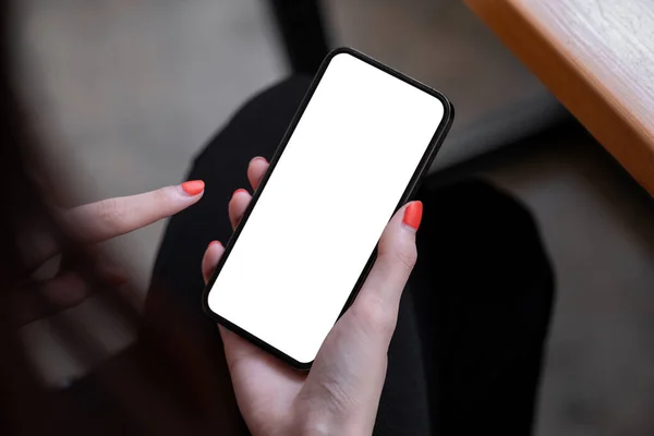 Vista superior imagem mockup de uma mulher segurando telefone celular preto com tela branca em branco enquanto sentado no café. — Fotografia de Stock