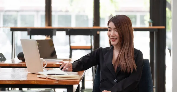 Schuss der schönen jungen asiatischen Frau, die am Laptop arbeitet, während sie im Café sitzt. — Stockfoto