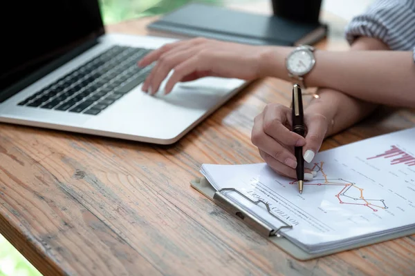 Primer plano contable analista celebración de documentos que trabajan con el ordenador portátil haciendo comercio en línea investigación tecnológica de mercado pensamiento de trabajo sentarse en el escritorio de la oficina en casa. — Foto de Stock