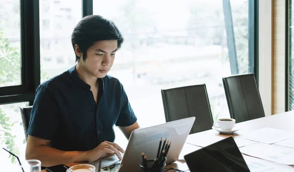 Joven hombre asiático trabajando en casa con ordenador portátil. Concepto financiero empresarial —  Fotos de Stock