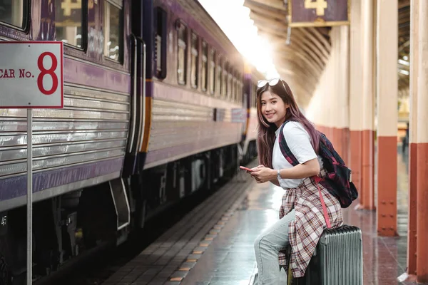 Retrato atracción asiática Mujer viajero turista sentado con el equipaje en la estación de tren. Concepto de estilo de vida activo y viajes. — Foto de Stock