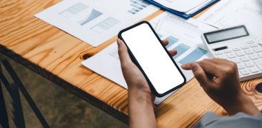 Close up business woman using mobile phone with blank white screen with business financial accounting background