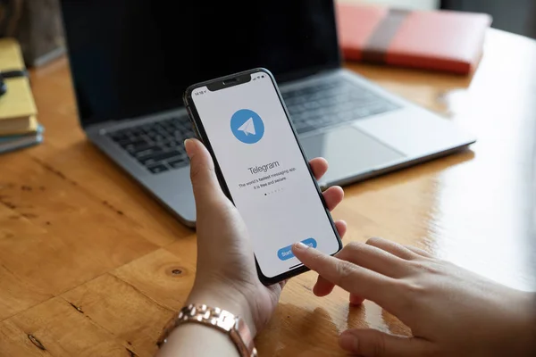 CHIANG MAI, TAILANDIA, 23 ENE 2021: Mano de mujer sosteniendo el iPhone 12 con servicio de redes sociales Telegram en la pantalla. iPhone 12 fue creado y desarrollado por Apple inc. — Foto de Stock