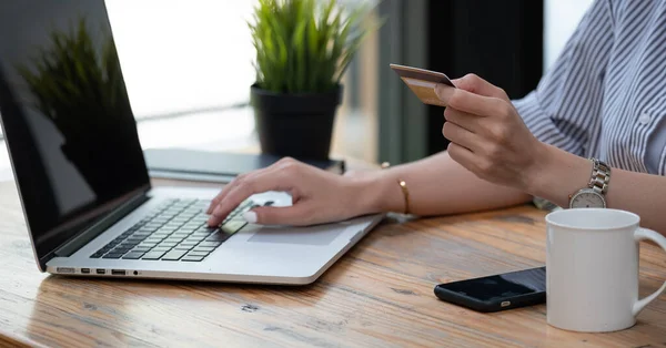 Close up mão de mulher asiática comprando on-line com computador portátil e cartão de crédito em casa — Fotografia de Stock