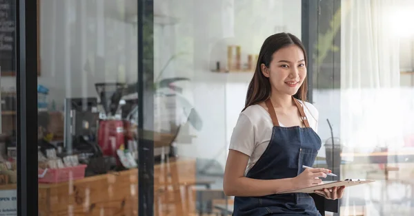 Alegre sorrindo jovem mulher asiática empresário no café balcão com ordem lista — Fotografia de Stock
