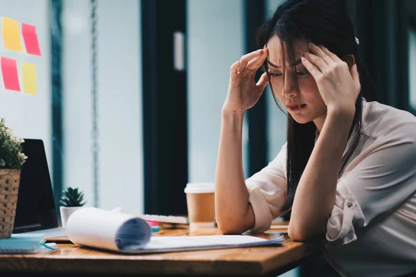 Müde junge Asiatinnen spüren Kopfschmerzen durch Arbeitsprobleme. Gestresste Frauen leiden unter Kopfschmerzen Sehschwäche am Arbeitsplatz. — Stockfoto