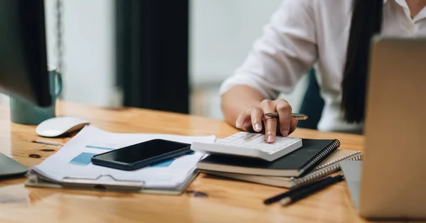 Nahaufnahme Frau Hand mit Taschenrechner und Laptop-Computer mit berechnen über die Kosten im Büro — Stockfoto