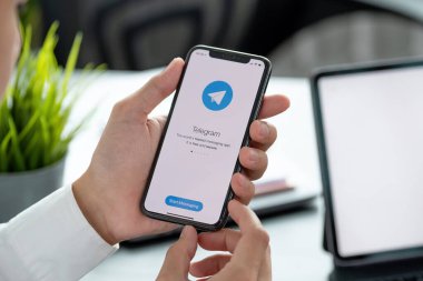 CHIANG MAI, THAILAND, APR 06, 2021: Ekranda sosyal ağ servisi telgrafı ile iPhone X 'i tutan adam. iPhone 10 Apple Inc. tarafından oluşturuldu ve geliştirildi