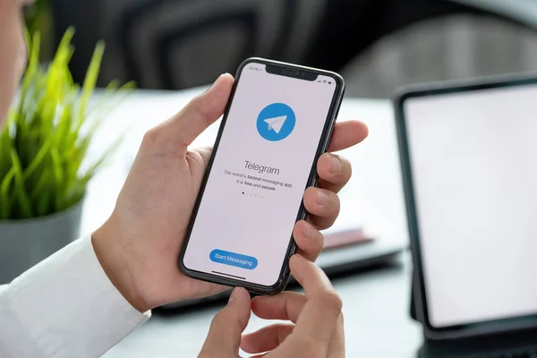 ЧЬЯН-ИЙ, ТАИЛАНД, 6 апреля 2021 года: Мужчина держит в руках iPhone X с сервисом социальной сети Telegram на экране. iPhone 10 был создан и разработан Apple inc — стоковое фото