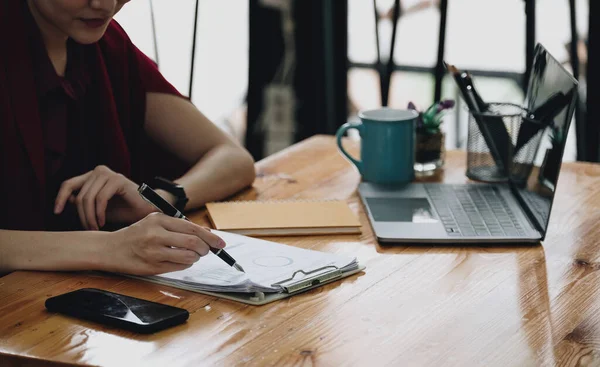 Mujer de negocios mantenga un bolígrafo para apuntar a gráficos, gráficos, finanzas, y analizar y calcular estrategias de planificación de procesos de planificación de éxito empresarial — Foto de Stock