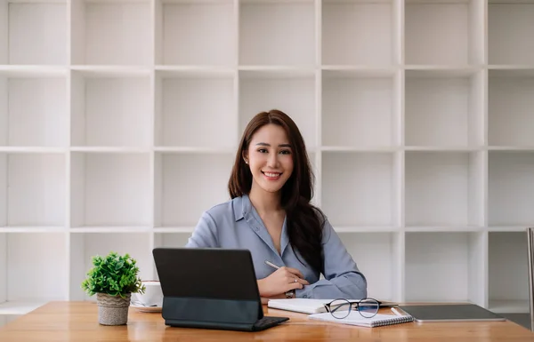 ポートレート｜魅力的なアジアのビジネスマン彼女のオフィスで木製の机の上にスマートタブレットで作業女性 — ストック写真