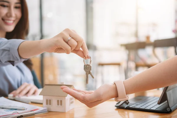 Client prenant les clés d'une agente immobilière pendant la réunion après avoir signé un contrat de location ou un contrat d'achat de vente. Femme indépendante achetant une nouvelle maison, vue rapprochée. — Photo