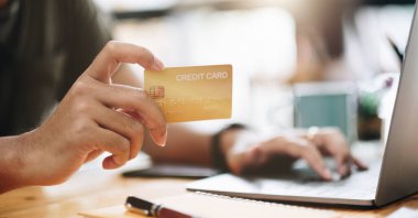 Çevrimiçi alışveriş konsepti, cep telefonu ve kredi kartı kullanan bir adam dizüstü bilgisayarla online ödeme yapıyor..