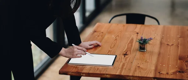 Cerca de la mano de la mujer de negocios de escritorio dibujo en una tableta de computadora de pantalla blanca en blanco — Foto de Stock