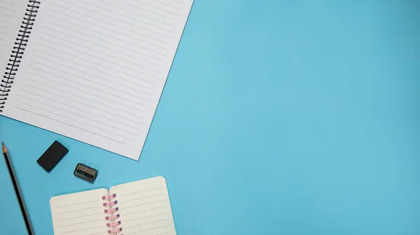 Educación o vuelta a la escuela Concepto. Vista superior de coloridos útiles escolares con libros, lápices de color, calculadora, clips de cortador de plumas y manzana sobre fondo azul pastel. Puesta plana —  Fotos de Stock