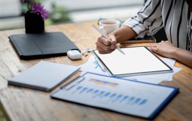 Yaratıcı kadınların el ele tutuştuğu beyaz boş ekran bilgisayar tabletini çizerek evdeki pazarlama planlamasına doğru kesilmiş bir resim.