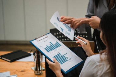 İş ekibi işbirliği mali veriler ve pazarlama büyüme raporlarıyla analiz etmeyi takım halinde, şirket kârından yararlanmak için strateji planlama, sunum ve beyin fırtınası grafiği üzerinde tartışır.