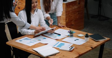 Ticari Asyalı ekip işbirliği finansal veriler ve pazarlama büyüme raporu grafiği, sunumu ve şirket karlı strateji planlama için beyin fırtınası analizini tartışır