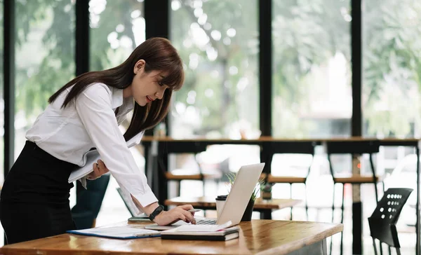 Vista lateral bastante joven mujer de negocios que trabaja con su computadora en la oficina. mujer asiática usando laptop — Foto de Stock