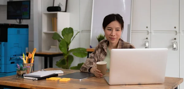 Glimlachende jonge aziatische tiener meisje video bellen op laptop. gelukkig mooi vrouw student kijken naar computer scherm kijken webinar of het doen van video chat door webcam — Stockfoto